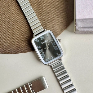 Macro shot of rectangular quartz watch with silver sunray dial and Roman numerals