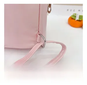 Gros plan des coutures fines et de la boucle en métal sur le sac rose en PU