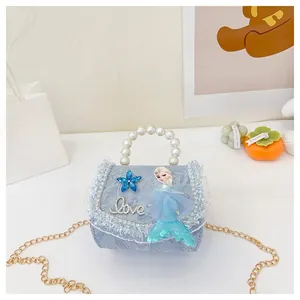 Détail du sac à main bleu pour enfant avec poignée en perles et bandoulière en chaîne