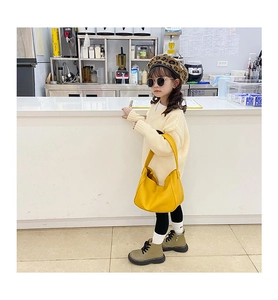 Fashionable young girl styling with bright yellow dumplings-shaped crossbody handbag