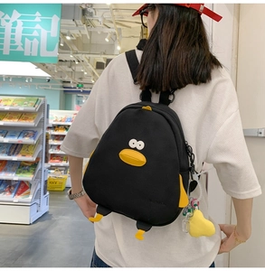 Rear view of a black canvas backpack featuring cute cartoon duck face and wings