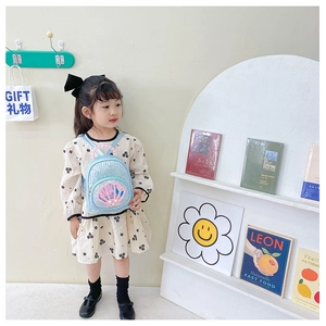 Detail of sequin kids backpack with shell pattern and pearl handle on a wooden hook