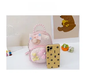 Sac à dos rose à paillettes pour enfant avec perles et nœud montrant la taille