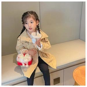 Detail of red plush kids handbag with pearl handle and lace bow on a khaki coat