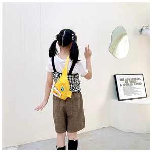 Detailed back view of a child wearing a yellow cartoon shark canvas chest bag with strap
