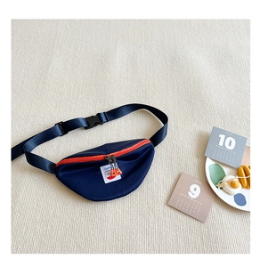 Close-up of navy canvas kids waist bag with vibrant orange zipper on soft textured background