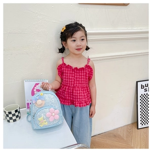 Détail du sac à dos bleu pailleté pour enfant avec décor floral et poignée perle