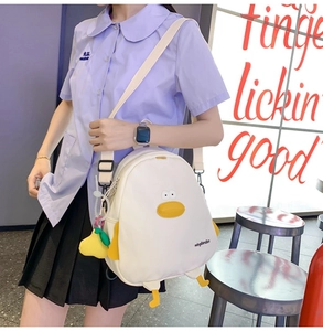 Cute white canvas duck backpack styled as a crossbody bag shown on a female model