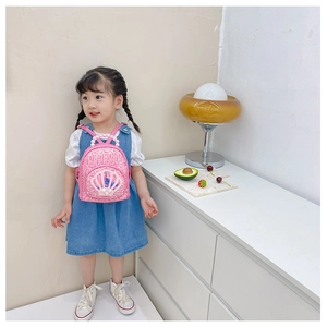 Toddler girl wearing pink sequin backpack with shell texture and pearl handle