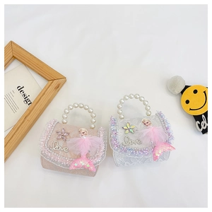 Gros plan de sacs en dentelle rose et blanche avec poignées en perles et poupées sirènes