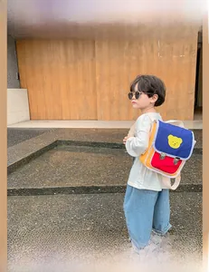 Détail du sac à dos enfant tricolore avec motif d'ours et sangles réglables