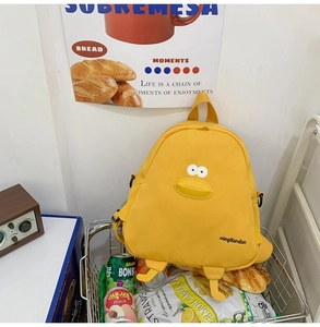 Detail of cute yellow cartoon chicken backpack with 3D duck features in a shopping cart