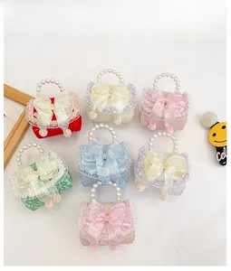 Flat lay of seven colorful lace toddler handbags with pearl handles and bow details