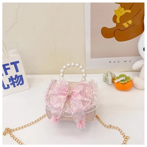 Close-up of pink girls' handbag with large sequin bow, lace trim and pearl handle details