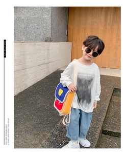 Sac à dos pour bambin avec design patchwork coloré et patch ours mignon sur un garçon