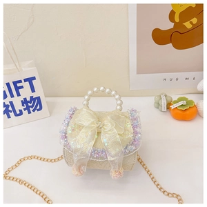 Detail of cream girls crossbody bag featuring pearl handle and sequin bow decoration