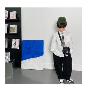 Style urbain enfant avec mini sac en nylon, bonnet vert et cravate à damier noir et blanc
