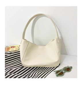 Macro detail of creamy white lychee grain faux leather on a stylish kid half-moon bag