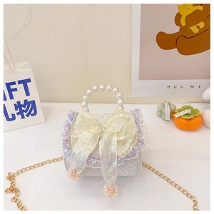 Detailed close-up of white lace girl handbag with pearl handle and sequin bow accent