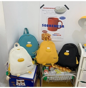 Detailed arrangement of cartoon chick backpacks in white, teal, yellow, and black colors