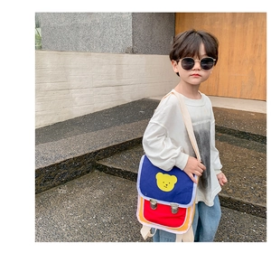 Photo de sac bandoulière coloré pour enfant avec motif d'ours jaune en extérieur