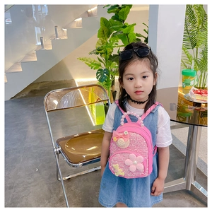 Vue détaillée du sac à dos rose pailleté pour enfant avec poignée en perles et fleur