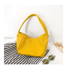 Detail of yellow pebbled leather dumpling bag for girls with wide shoulder strap