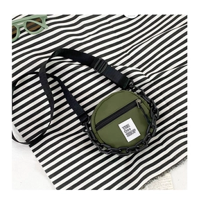 Détail d'un petit sac rond olive pour enfant en nylon avec chaîne en plastique noir