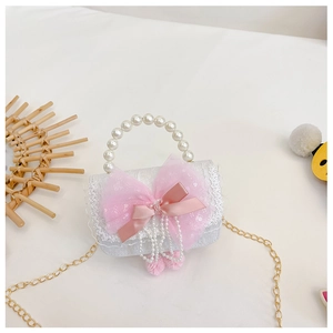 Details der weißen Kinder-Spitzentasche mit rosa Tüllschleife und Perlenhenkel