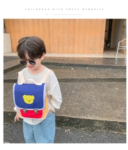 Détail du sac à dos enfant tricolore avec motif ours jaune et boucles métalliques