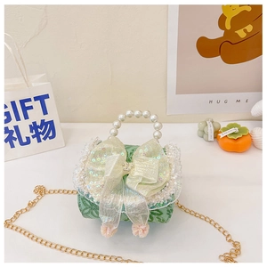 Detail of green floral kids mini handbag with organza bow and pearl handle texture