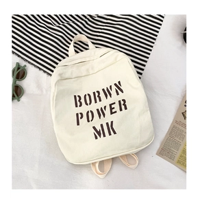 Close-up of beige canvas backpack featuring bold Brown Power MK letter printing