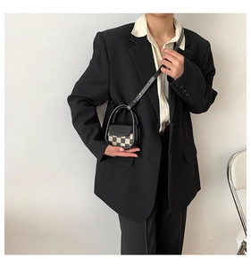Mini checkerboard crossbody bag with top handle shown on a model for scale and fit