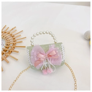 Detail der grünen Kindertasche mit rosa Spitzenschleife, Perlengriff und Goldkette
