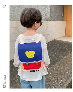 Vue détaillée du sac à dos enfant avec motif ours, contraste bleu-rouge et boucles en métal