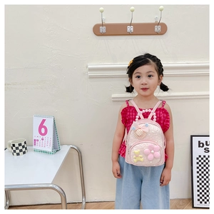 Détail d'un sac à dos rose pour enfant avec paillettes, poignée perle et décor d'ours