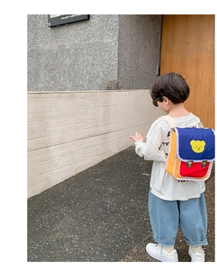 Détail du sac à dos enfant coloré avec motif ours jaune et boucles en métal argenté