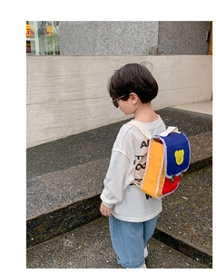 Vue détaillée d'un enfant portant le sac à dos ours de dessin animé jaune, rouge et bleu