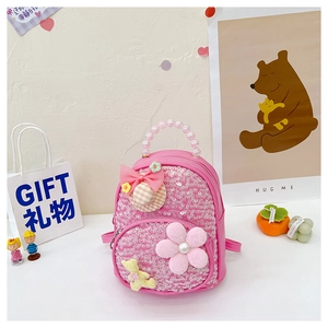 Détail du sac à dos rose à paillettes avec poignée en perles, nœud et petit ours mignon