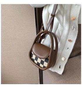 Detailed view of mini checkered crossbody bag with brown leather trim and thin strap