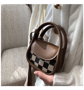 Detailed shot of a mini checkered crossbody bag with brown leather handles and strap