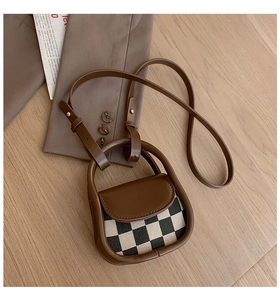 Detail of mini checkered crossbody bag with brown leather trim and magnetic flap cover