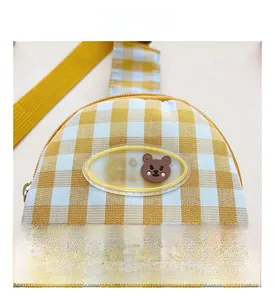 Détail du sac de poitrine enfant à carreaux jaunes avec écusson ours mignon