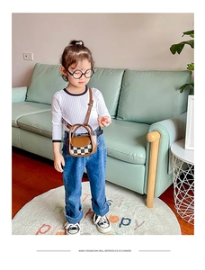 Close-up of mini checkered crossbody bag for girls with brown leather handle and strap