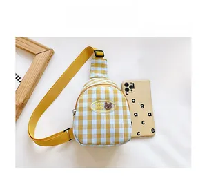Détail du sac de poitrine à carreaux jaunes pour enfants avec téléphone de référence
