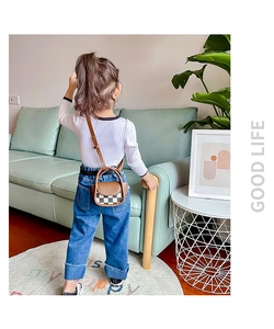 Toddler mini checkerboard crossbody bag with brown leather strap shown from a back view