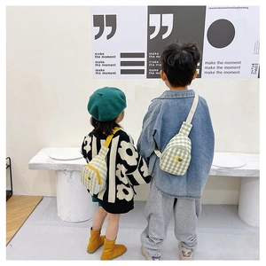 Détail de sacs de poitrine à carreaux pour enfants en jaune et vert avec écussons ours