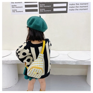Détail du sac de poitrine à damier jaune pour enfants avec sangle et badge ours