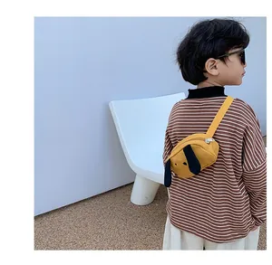 Close-up of a child wearing a yellow canvas puppy chest bag with long black ears