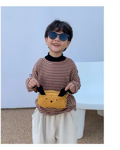 Detailed view of yellow cartoon puppy waist bag with 3D ears on a young boy model